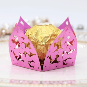 Close-up of laser-cut clover candy box in metallic rose pink with gold chocolate