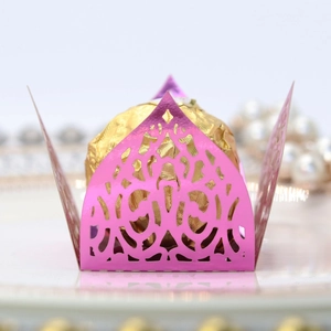Macro view of laser-cut pink hollow crown candy wrapper with lace details for party favor