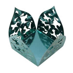 Macro view of metallic green clover laser-cut hollow candy box with mirror finish