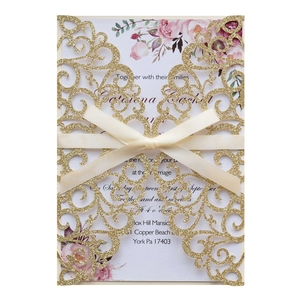 Golden glitter laser-cut wedding invitation with ivory ribbon and floral print interior