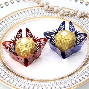 Detailed view of hollow butterfly favors with red and blue paper and gold chocolate