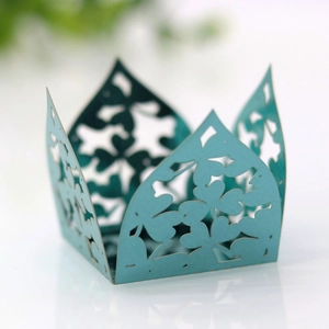 Detail of laser-cut cyan cupcake wrapper with crown edge and floral hollow design