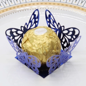 Detail view of laser cut butterfly candy cup in navy blue with gold foil chocolate