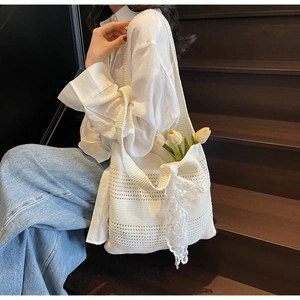 Gros plan d'un sac cabas au crochet blanc avec dentelle et tulipes sur un escalier