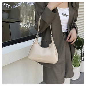 Detailed close-up of a beige hobo shoulder bag with a sleek minimalist design and zipper