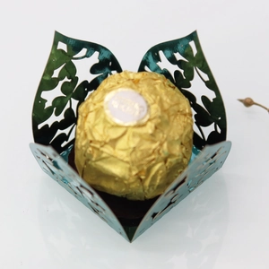 Macro detail of dark green laser cut clover candy box with metallic glossy finish