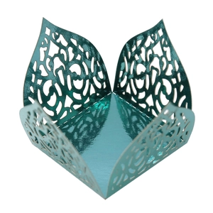 Detail of laser-cut teal metallic candy box featuring intricate filigree vine patterns
