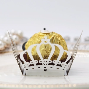 Macro detail of laser-cut crown pattern paper candy wrapper with heart and lace design