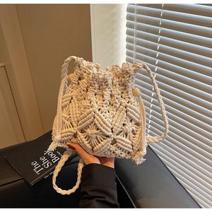 Detail of bohemian macrame woven bag featuring wood bead accents and fringe tassels