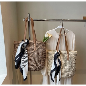 Detail of woven straw tote bags with leather straps and decorative geometric scarves