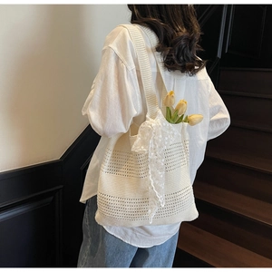 Gros plan du sac fourre-tout en tricot ajouré blanc orné d'un nœud en dentelle délicate