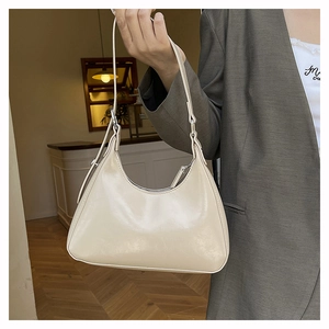 Side view of beige matte PU leather hobo bag with adjustable silver metal buckle detail