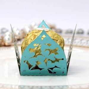 Macro shot of laser-cut teal lace candy wrapper for chocolate with elegant floral pattern