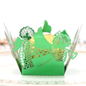 Détail d'un emballage vert découpé au laser avec motif d'ange pour cupcakes et bonbons