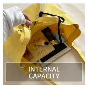 Interior view of yellow canvas tote showing ample space for a tablet, books, and cosmetics