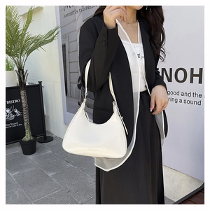 Detail of off-white minimalist hobo bag with smooth texture and adjustable shoulder strap