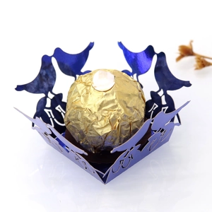 Detail of laser-cut bird hollow candy box in navy blue pearl paper for weddings