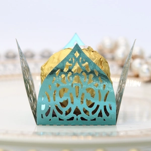 Detail of laser-cut light blue chocolate wrap with elegant pattern on a white porcelain plate