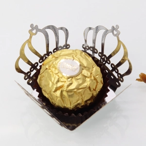 Close-up of laser-cut crown hollow chocolate box with metallic gold finish and lace edges