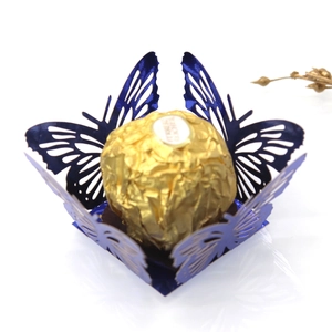 Macro detail of laser-cut blue butterfly lace packaging for chocolate and candy decorations