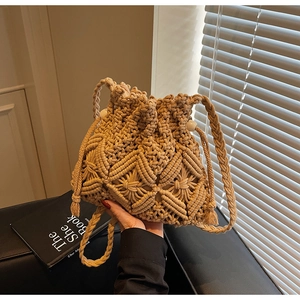 Detail of woven bucket bag with hollow diamond pattern and stylish tassel accents