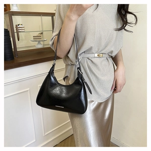 Detailed close-up of a glossy black faux leather hobo bag with Fashion & Bags logo print