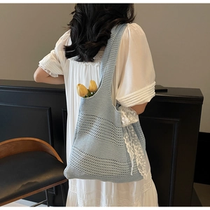 Gros plan du sac à bandoulière en tricot bleu clair avec dentelle et décorations