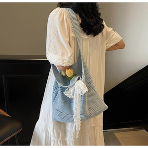 Vue détaillée d'un sac cabas tricoté bleu clair avec nœud en dentelle et tulipes