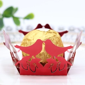 Macro shot of red laser-cut candy box with bird patterns and golden chocolate detail