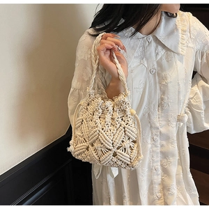 Detail of hand-woven cream cotton bucket bag showing geometric diamond hollow patterns
