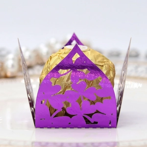 Macro view of purple laser-cut floral candy box with gold chocolate inside