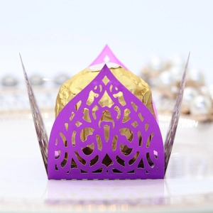 Macro shot of laser-cut purple mirror paper chocolate wrapper with floral hollow patterns