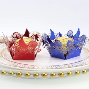 Détail de caissettes à bonbons anges découpées au laser en rouge et bleu nacré sur plat