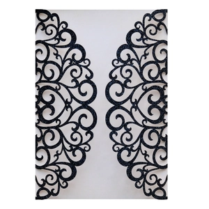 Macro shot of laser cut black glitter wedding invitation cover with intricate floral pattern