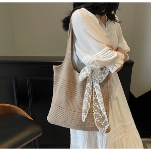 Détail du sac cabas au crochet kaki avec de larges rubans en dentelle blanche sur le côté