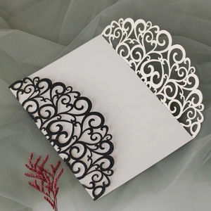 Detail of laser-cut wedding invitation featuring glitter finish and elegant floral patterns