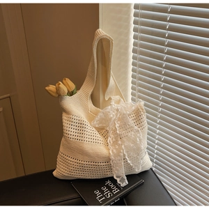 Détails du tissage et du nœud en dentelle sur un sac à bandoulière en maille crème