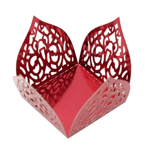 Macro view of red laser-cut hollow candy box with floral patterns and metallic finish