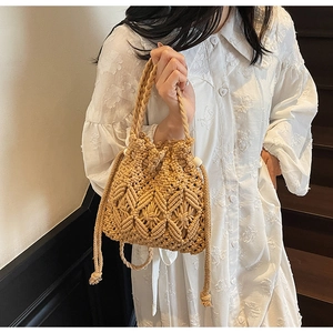 Macro detail of beige woven bucket bag with intricate openwork patterns and wooden beads