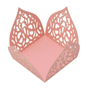 Detail of pink laser-cut lace cupcake wrapper with intricate floral hollow pattern