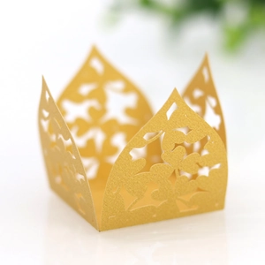 Makro-Detail des lasergeschnittenen Kleeblattmusters auf goldener Spiegel-Bonbonschachtel
