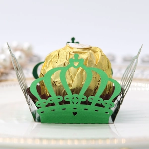 Detail of laser-cut crown paper cupcake liner in green with golden chocolate display