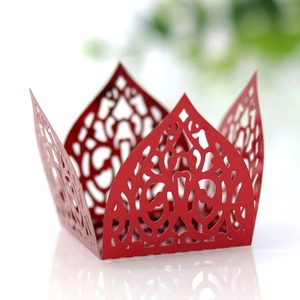 Detailed laser-cut hollow crown design on red paper candy box with intricate floral patterns