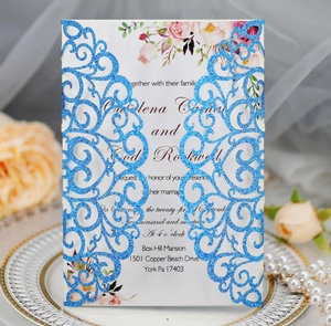 Detail of laser-cut glitter wedding invitation with floral insert on elegant background