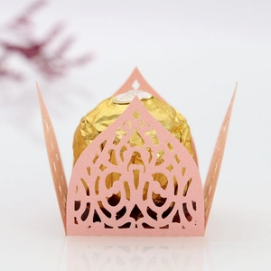 Macro detail of pink laser-cut crown candy box with intricate European floral patterns