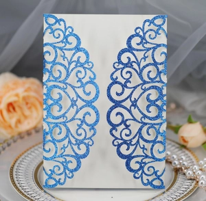 Detail of blue glitter laser-cut wedding invitation with elegant vine and heart motifs