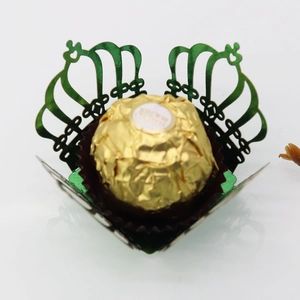 Close-up of green laser-cut crown chocolate wrapper with fine hollow lace pattern