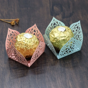 Detail of laser-cut paper chocolate wrappers with pink and teal rose lace patterns