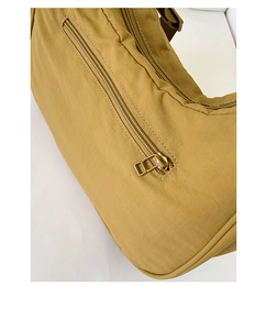 Détail du sac à bandoulière en nylon jaune moutarde avec fermeture éclair en métal