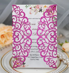 Macro detail of laser cut wedding invitation with glitter finish and floral inner card